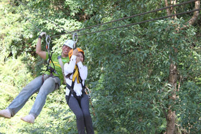 Woman in orange hat, man in white hat, both on cable